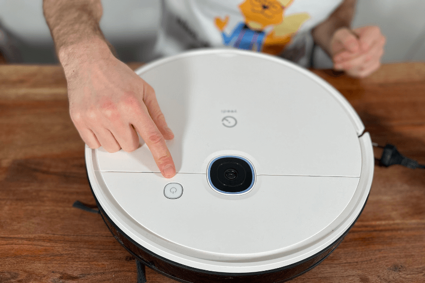 Die Oberfläche des Yeedi Vac Hybrid ist von oben zu sehen, wobei die Oberfläche mit einem Finger berührt wird.